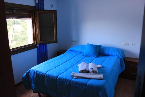 a bedroom with a blue bed with towels on it at Casa Pampaneira 3 Hab 2 baños Terraza+Chimenea in Pampaneira