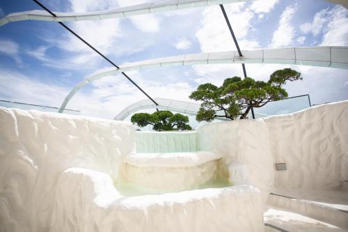 a white room with a tree in the background at ARTE MONT KIARA BY PSM Luxury Suites in Kuala Lumpur