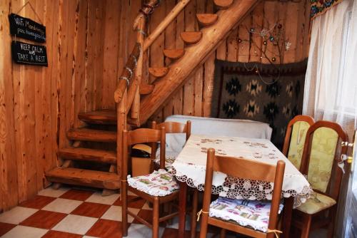 a table and chairs in a room with a staircase at Guest House Mandrivnyi Rooms&Apartments in Yasinya