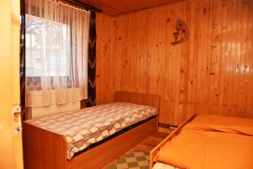 a bedroom with two beds in a wooden room at Guest House Mandrivnyi Rooms&Apartments in Yasinya
