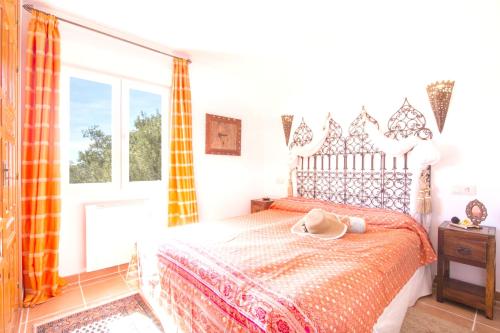 a bedroom with a bed with a hat on it at 3 bedrooms house with sea view private pool and enclosed garden at Teulada 1 km away from the beach in Teulada
