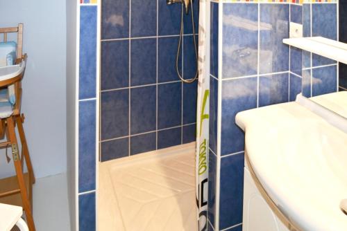 a shower in a bathroom with blue tiles at Maison de 2 chambres avec jardin clos et wifi a Plomelin in Plomelin