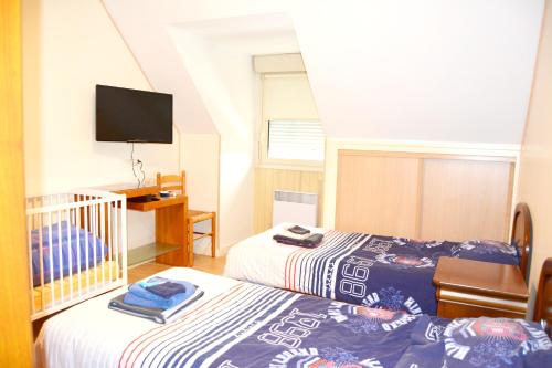 a bedroom with two beds and a crib at Maison de 2 chambres avec jardin clos et wifi a Plomelin in Plomelin