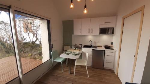 une cuisine avec une table et des chaises et une fenêtre dans l'établissement Gîte Petite Folie Nantaise, à 2 pas de la Loire, à Mauves-sur-Loire