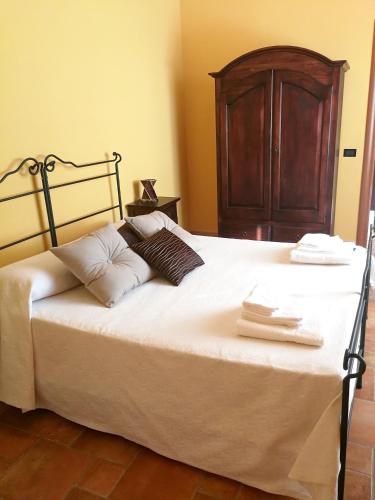 a bed with a wooden headboard and pillows on it at Charming apartment in Montallegro with sea view in Montallegro