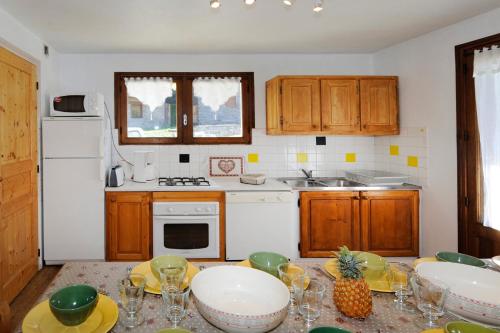 une cuisine avec des placards en bois et une table avec des verres à vin dans l'établissement Appartement moderne aux Menuires - 90 m² - Vue montagne, à Levassaix