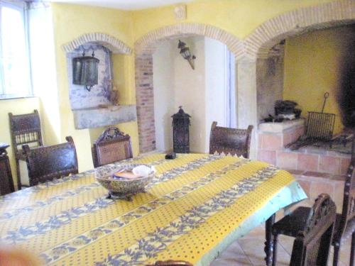 une salle à manger avec une table aux motifs jaune et bleu dans l'établissement Manoir enchanteur à Cailhau avec piscine privée sécurisée, à Cailhau