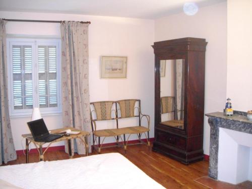 a living room with a chair and a mirror at Manoir enchanteur à Cailhau avec piscine privée sécurisée in Cailhau