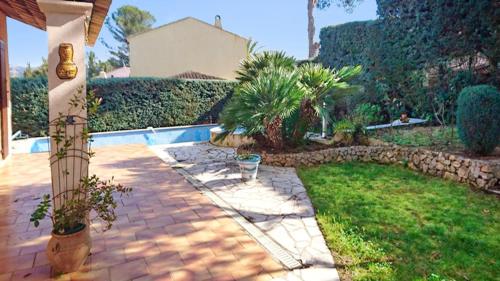 a backyard with a stone walkway and a pool at Villa avec piscine à Saint-Raphaël et vue sur la montagne in Saint-Raphaël