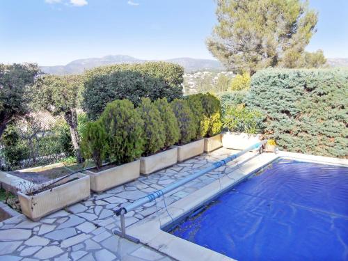 una piscina en un patio con árboles y arbustos en Villa de 3 chambres avec piscine privee jardin clos et wifi a Saint Raphael a 6 km de la plage, en Saint-Raphaël