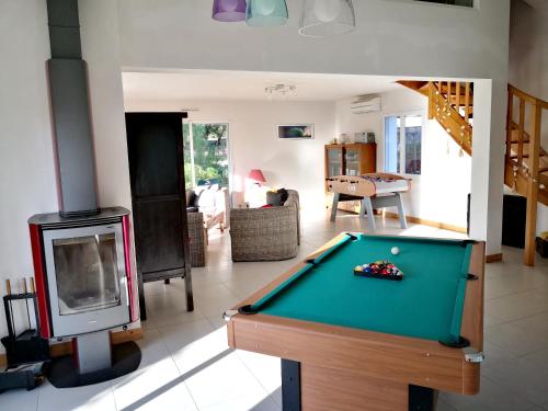 a living room with a pool table and a fireplace at Maison de 3 chambres a La Tranche sur Mer a 800 m de la plage avec jardin clos in La Tranche-sur-Mer