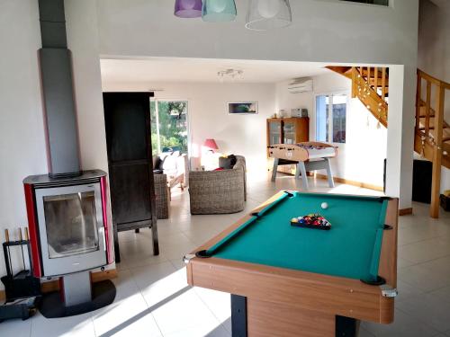 a living room with a pool table and a fireplace at Maison charmante à La Tranche-sur-Mer avec jardin clos in La Tranche-sur-Mer
