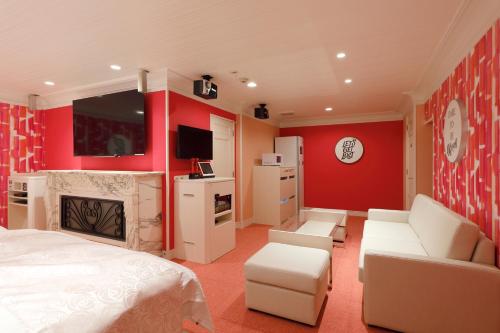 ホテルバースデーきよす店 HOTEL Birthday kiyosu في Kiyosu: غرفة نوم بجدران حمراء وسرير ومدفأة