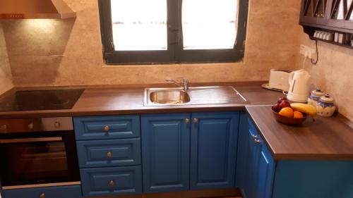 a blue kitchen with a sink and a bowl of fruit at Charming House in Ix - Xewkija with Terrace and Barbecue in Xewkija
