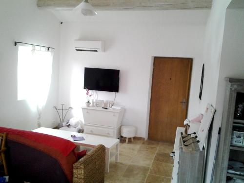 a living room with a bed and a tv on the wall at Villa confortable avec piscine privée à Saint-Saturnin-lès-Apt in Croagnes
