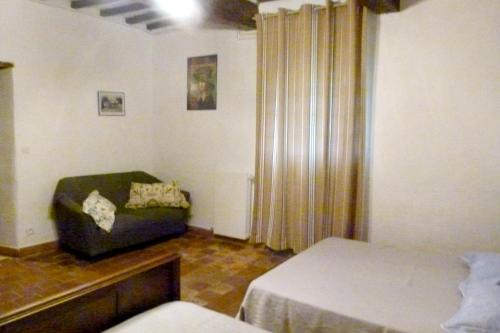 une chambre avec un lit et un canapé dans une pièce dans l'établissement Villa confortable proche d'Ornézan avec piscine privée, à Ornézan