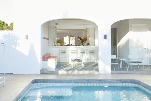 a house with a swimming pool and a dining room at The Sails Motel Brunswick Heads in Brunswick Heads