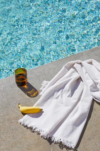 a banana and a towel next to a swimming pool at The Sails Motel Brunswick Heads in Brunswick Heads