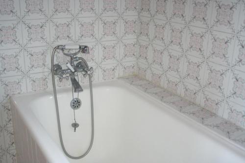 La salle de bains est pourvue d'une baignoire et d'une douche. dans l'établissement Chalet de 7 chambres avec sauna jardin et wifi a Briancon a 1 km des pistes, à Briançon