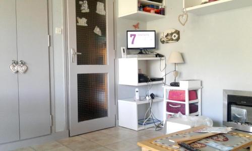 Sala de estar con puerta y TV en Studio avec terrasse amenagee et wifi a Allevard, en Allevard