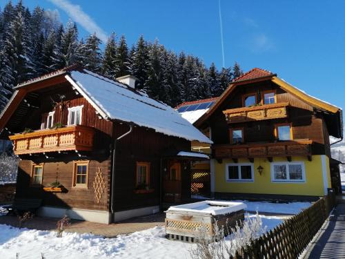 a wooden house in the snow with a fence at Chalet Taurachblick in Tamsweg