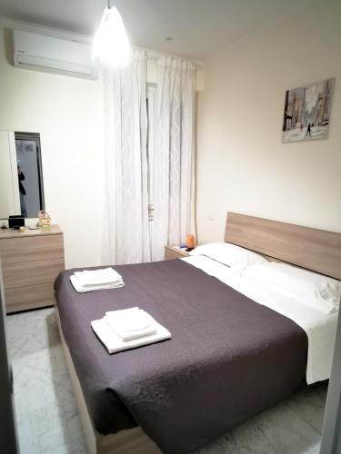 a bedroom with a large bed with two towels on it at Modern Apartment in the Heart of Rome, 42 m², Parking Included in Rome
