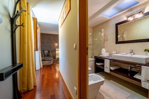 a bathroom with a sink and a toilet and a mirror at Luxurious House in Braga with Pool in Barreiros