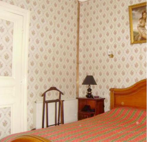 ein Schlafzimmer mit einem Bett, einem Tisch und einem Stuhl in der Unterkunft Maison de 3 chambres avec jacuzzi jardin clos et wifi a Gabarret in Gabarret