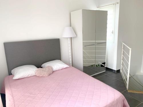 a bedroom with a pink bed with a pink blanket at Appartement d'une chambre a Le Moule a 200 m de la plage avec piscine privee terrasse amenagee et wifi in Le Moule