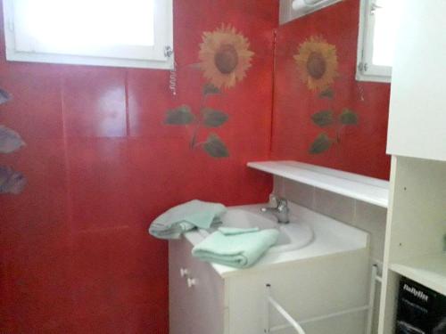 baño con lavabo y pared roja en Appartement d'une chambre avec piscine partagee jardin clos et wifi a Le Luc en Le Luc