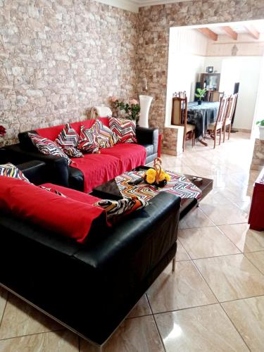 a living room with a black couch with red pillows at Charming House in Costa Calma with Mountain View and Terrace in Costa Calma