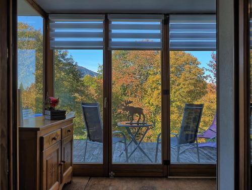 une cuisine avec des portes coulissantes en verre avec un chien sur une table dans l'établissement Appartement cosy aux Carroz, 40 m², vue sur la montagne, aux Carroz d'Arâches