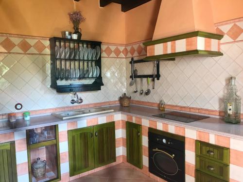 eine Küche mit grünen Schränken und einem Herd in der Unterkunft 3 bedrooms villa with private pool and furnished terrace at El Saucejo in Saucejo