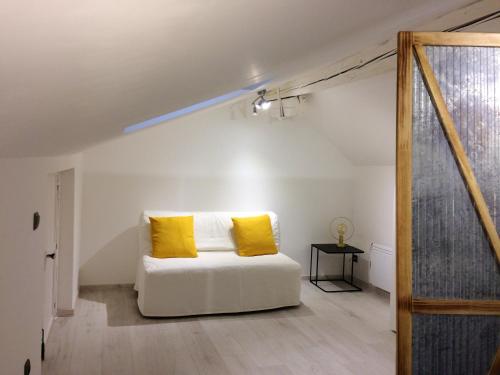 1 cama blanca con almohadas amarillas en una habitación en Maison de 4 chambres avec vue sur la ville jardin clos et wifi a Cirey sur Vezouze en Cirey-sur-Vezouze