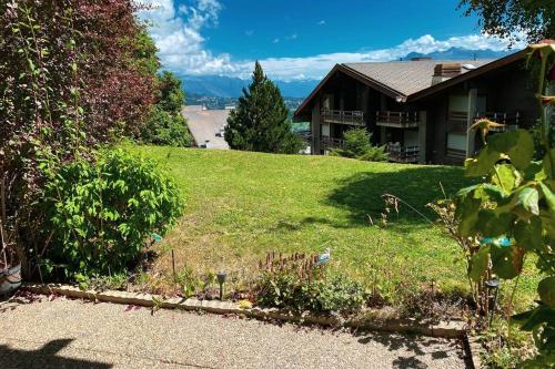 a house on a hill with a yard with a grassy field at Anzère - Appartement 2 pièces au pied du télécabine in Anzère