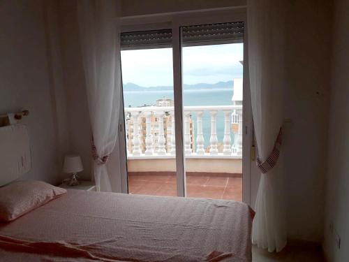 拉曼加戴爾馬爾梅納的住宿－2 bedrooms appartement at La Manga 100 m away from the beach with sea view furnished terrace and wifi，一间卧室设有一张床,享有阳台的景色