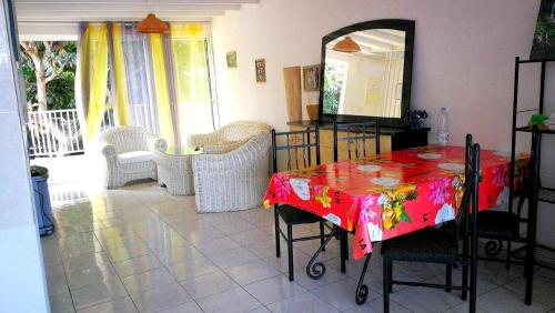 a dining room with a table and chairs and a mirror at Appartement confortable à Saint-Paul 70 m² avec piscine partagée in Saint-Paul