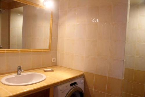 une salle de bain avec un lavabo et une machine à laver dans l'établissement Appartement lumineux avec vue sur montagne à Saint-Raphaël, à Saint-Raphaël