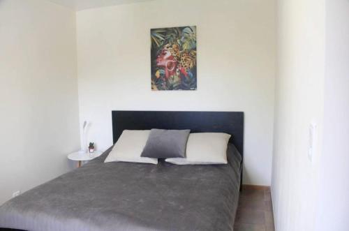 une chambre avec un lit avec un tableau sur le mur dans l'établissement Appartement lumineux avec vue sur montagne à Saint-Raphaël, à Saint-Raphaël