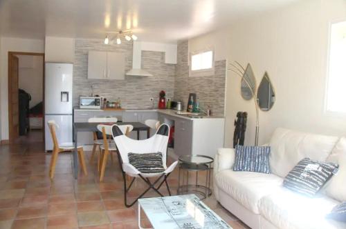 un salon avec un canapé blanc et une cuisine dans l'établissement Appartement lumineux avec vue sur montagne à Saint-Raphaël, à Saint-Raphaël