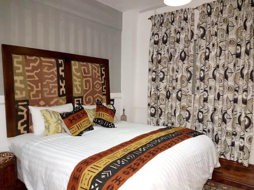 a bedroom with a bed with a large white bedspread and a curtain at Family apartment with sea view - 140 m² in Trou d'Eau Douce in Trou dʼ Eau Douce