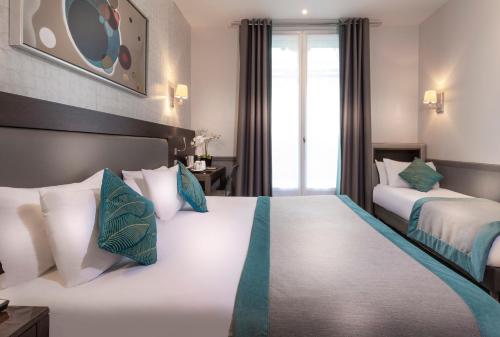 a hotel room with two beds and a window at Elysées Ceramic in Paris