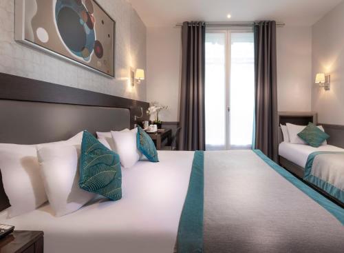 a hotel room with two beds and a window at Elysées Ceramic in Paris