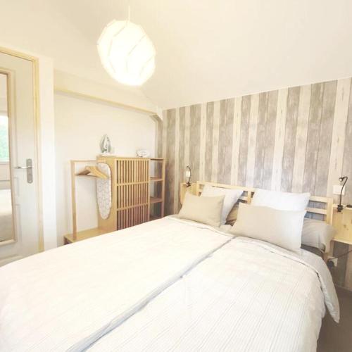 une chambre avec un grand lit avec des draps blancs dans l'établissement Maison cosy à Chouzy sur Cisse avec jardin, à Chouzy-sur-Cisse