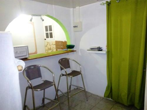 2 sillas sentadas en una habitación con ventana en Appartement d'une chambre avec jardin amenage et wifi a Saint Esprit en Quartier Morne Acajou