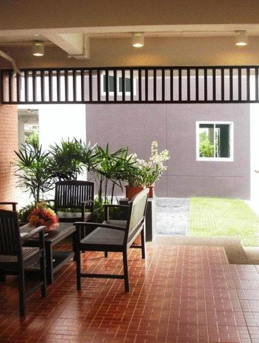a patio with two chairs and a table with plants at The Ivory, Suvarnabhumi Airport in Lat Krabang