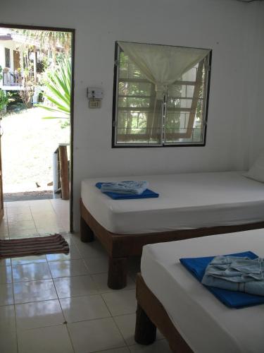 two beds in a room with a window at Thai Dee Garden Resort in Haad Rin