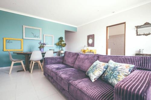 a purple couch in a living room with a table at Modern apartment in Estói with shared pool. in Estói