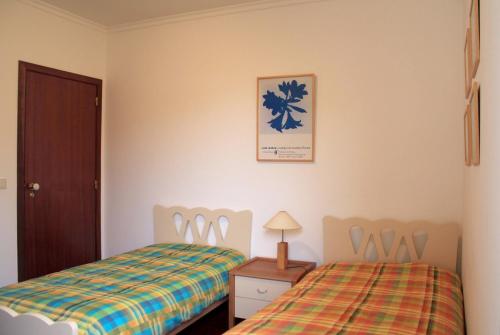 ポルト・サントにある3 bedrooms house at Porto Santo 500 m away from the beach with enclosed garden and wifiのベッドルーム1室(ベッド2台、ランプ付)
