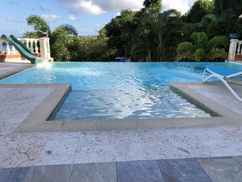 een zwembad met een stoel en een glijbaan bij Maison de 2 chambres avec vue sur la mer piscine partagee et jardin clos a La Trinite a 2 km de la plage in La Trinité